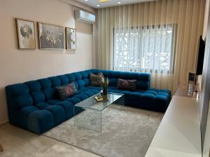 a blue couch in a living room with a glass table at Studio cosy chic in Casablanca