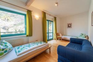 a living room with a blue couch and a window at Passerhaus Schenna in Schenna