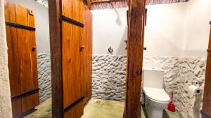 a bathroom with a toilet in a room at Kitesurf Tofo House in Praia do Tofo
