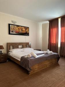 een slaapkamer met een groot bed en handdoeken bij Семейный отель in Tbilisi City