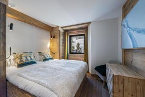 1 dormitorio con cama y ventana en Appartement Blanchot - LES CHALETS COVAREL en Val dʼIsère