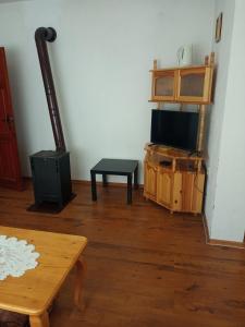 een woonkamer met een tv en een tafel bij Family Hotel Shisharka in Batak