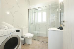 a bathroom with a shower and a toilet and a washing machine at Arieni Places in Corfu