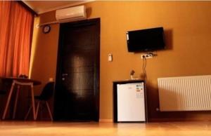 een kamer met een zwarte deur en een kleine koelkast bij Семейный отель in Tbilisi City