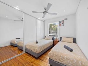 a bedroom with two beds and a ceiling fan at Quaint Aussie 2Br plus 1 loft - Casino & ICC & Chinatown & Darling Harbour & Fish Market in Sydney