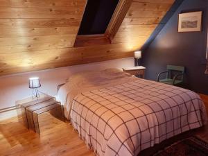 - une chambre avec un lit dans une pièce dotée de murs en bois dans l'établissement Maison de pêcheur proche plage et activités, à Crozon