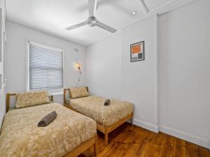 a bedroom with two beds and a ceiling fan at Quaint Aussie 2Br plus 1 loft - Casino & ICC & Chinatown & Darling Harbour & Fish Market in Sydney