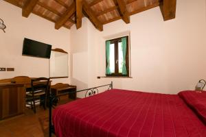 a bedroom with a bed and a desk and a television at Il Podere Del Germano Reale in Coriano
