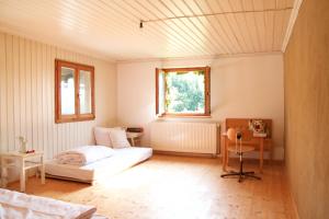 Cette chambre comprend un lit, une table et une fenêtre. dans l'établissement Stadt Land Freunde, à Wangen im Allgäu