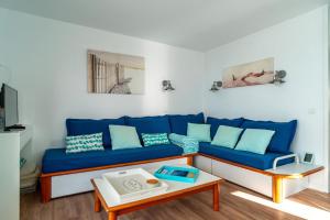 ein Wohnzimmer mit einem blauen Sofa und einem Tisch in der Unterkunft Didou - T3 vue mer - plage à 40m in Bénodet