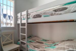 ein Schlafzimmer mit zwei Etagenbetten und einem Bett in der Unterkunft Didou - T3 vue mer - plage à 40m in Bénodet