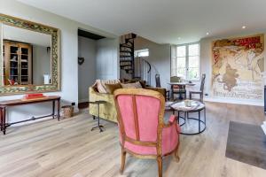 ein Wohnzimmer mit einem Sofa und einem Tisch in der Unterkunft La petite châtelaine - Charmante maison au calme 