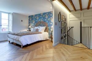 Schlafzimmer mit einem Bett mit blauer Wand in der Unterkunft La petite châtelaine - Charmante maison au calme 