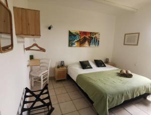 Un dormitorio con 2 camas y una silla. en Mas La belle Ambroise - Chambres d'hôtes et Gîte, en Saint-Ambroix