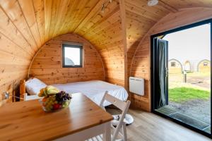 Zimmer mit einem Bett und einem Tisch in einer Hütte in der Unterkunft Camping Pods Silver Sands Holiday Park in Lossiemouth