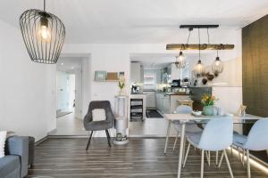 cocina y sala de estar con mesa y sillas en Ferienwohnung Mittenglück en Unterlenningen