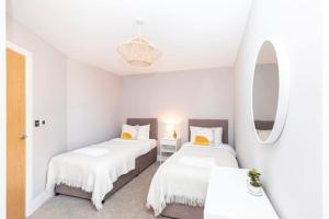 2 łóżka w małym pokoju z lustrem w obiekcie Close to beach, parking, 2 bed flat with garden - Meraki Luxe w mieście Southbourne