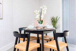 stół jadalny z krzesłami i czarny stół w obiekcie Close to beach, parking, 2 bed flat with garden - Meraki Luxe w mieście Southbourne