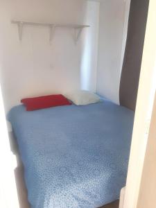 Cama en habitación pequeña con almohada roja en Propriete de 3 chambres avec jardin clos a Saint Pierre en Saint-Pierre