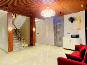 ein Wohnzimmer mit einem roten Sofa und einer Treppe in der Unterkunft Hotel Krishna Residency Bareilly Near Ashish Royal Park in Bareilly