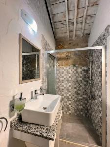 uma casa de banho com um lavatório e um chuveiro em Köşem Konukevi em Alacati