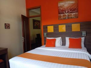 - une chambre avec un grand lit aux murs orange dans l'établissement Alamsagita Puncak Hotel & Resort, à Ciloto
