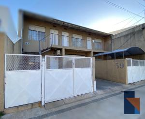 a white gate in front of a building at Deptos Ayacucho 59 in Venado Tuerto