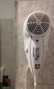 a white hair dryer is standing in a room at Ayacucho 59 in Venado Tuerto