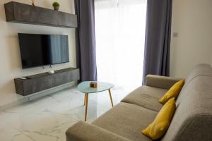 ein Wohnzimmer mit einem Sofa und einem TV in der Unterkunft RA6 - NEW, bright & spacious - Sliema-Gzira area! in Gżira