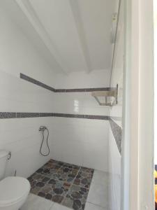 uma casa de banho com WC e piso em azulejo em Les cattleyas em Petit-Bourg