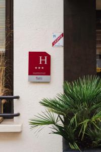 a sign on the side of a building with a plant at L'Hôtel Bristol in Caen