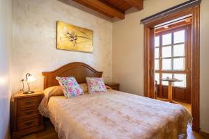 um quarto com uma cama grande e uma janela em Aldea Salguero 