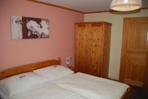a bedroom with a bed and a wooden cabinet at Ferienwohnung Lahnerhof in Arriach +33 photos