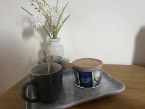 a tray with two cups of coffee and a vase with flowers at Myrtle Villas in Hull