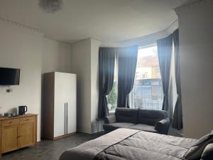 a bedroom with a bed and a chair and a window at Myrtle Villas in Hull