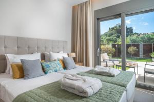 a bedroom with two beds and a large window at Villa MANDI & JANI in Laganas