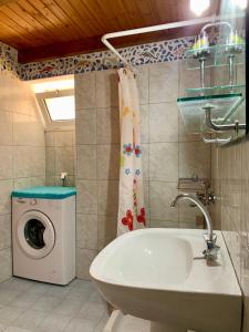 a bathroom with a washing machine and a white sink at Morea Bay View in Tourlotí
