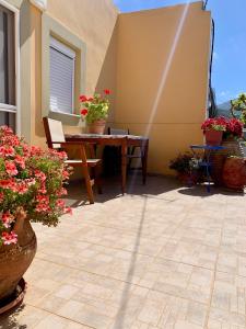 a patio with a table and potted flowers at Morea Bay View in Tourlotí