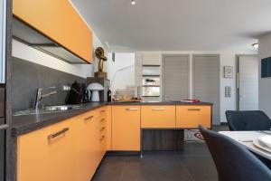 una cucina con mobili arancioni e un lavandino di Casa Tramontana by Briskva a Funtana