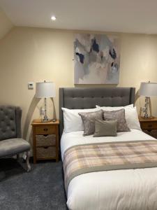 a bedroom with a large bed and a chair at Waverley Inn House in Inverness