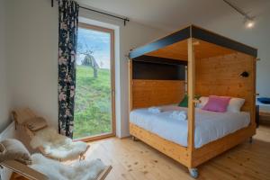 - une chambre avec un lit à baldaquin et une fenêtre dans l'établissement Eko Glamping Resort Krištof, à Cerklje na Gorenjskem