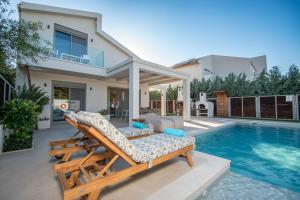 een villa met een zwembad en een huis bij Villa MANDI & JANI by "elite" in Laganas