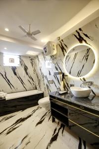 uma casa de banho com um lavatório, um WC e um espelho. em The Embassy Inn em Noida