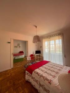 sypialnia z dużym łóżkiem i czerwonym kocem w obiekcie 100 Contos w Porto