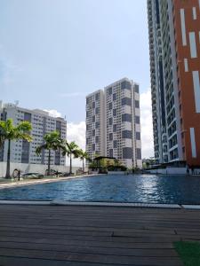 a swimming pool in the middle of two tall buildings at Comfortable18 3R2B 7pax Meritus Perai in Perai