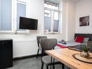 a living room with a table and chairs and a tv at Serviceroom24 - Apartment 2 in Recklinghausen Hoch WLAN - Smart-TV - 24-7 Check-in und Küche in Recklinghausen