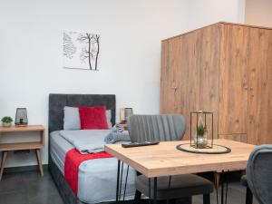 a bedroom with a bed and a wooden table at Serviceroom24 - Apartment 2 in Recklinghausen Hoch WLAN - Smart-TV - 24-7 Check-in und Küche in Recklinghausen