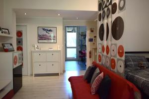 a living room with a red couch and a kitchen at Casa Laghetto Policlinico in San Donato Milanese