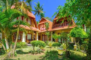 a house with palm trees in front of it at Jineng 5 BR Private Pool Villa with Stunning Garden by Basma Groups in Ubud