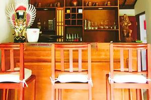 two wooden chairs sitting in front of a bar at Jineng 5 BR Private Pool Villa with Stunning Garden by Basma Groups in Ubud